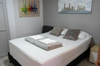 a bed with white sheets and pillows on it at Apartamento Parque Central Guatapé in Guatapé