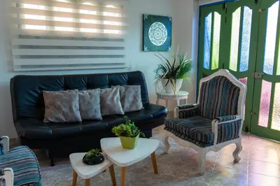 a living room with a black couch and a chair at Apartamento Parque Central Guatapé in Guatapé