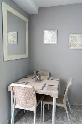 a dining room table with two chairs and a white wall at Apartamento Parque Central Guatapé in Guatapé