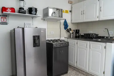 a kitchen with a stainless steel refrigerator and a stove at Apartamento Parque Central Guatapé in Guatapé