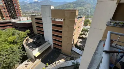 an aerial view of a building with mountains in the background at Apartamento en Bello in Bello