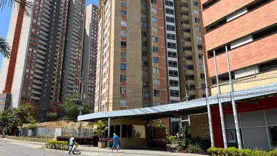 two people walking down a street in front of tall buildings at Apartamento en Bello in Bello