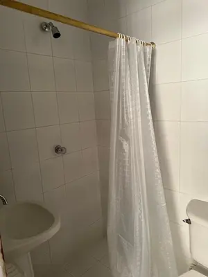 a bathroom with a shower curtain and a toilet at Hotel Sandiego in Puerto Berrío