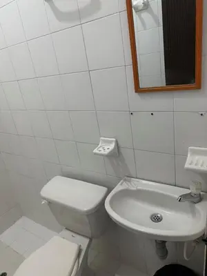 a white bathroom with a toilet and a sink at Hotel Sandiego in Puerto Berrío