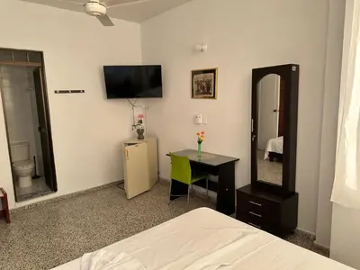a bedroom with a bed and a desk and a mirror at Hotel Sandiego in Puerto Berrío