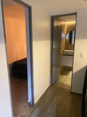 a door leading to a bedroom with a bed and a mirror at The oasis apartamento de 3 alcobas Laurles estadio LA70 in Medellín