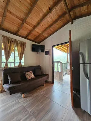 a living room with a couch and a refrigerator at Cabaña Los Colibríes in San Rafael