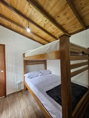a bedroom with two bunk beds with wooden ceilings at Cabaña Los Colibríes in San Rafael