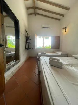 a room with two beds and a window and a sink at Finca Hotel el Valhalla in Doradal