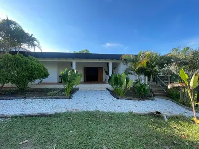 a house with palm trees in front of it at Finca Hotel el Valhalla in Doradal