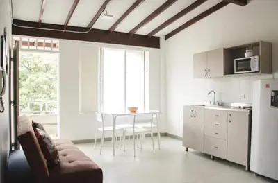 a kitchen with a couch and a table in a room at Amoblados Medellin Estadio in Medellín