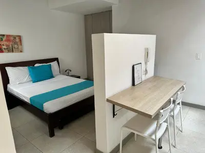 a small bedroom with a bed and a desk at Amoblados Medellin Estadio in Medellín