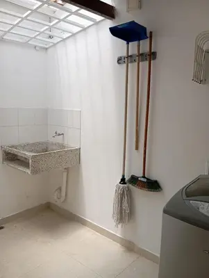 a bathroom with a sink and a broom on the wall at Amoblados Medellin Estadio in Medellín