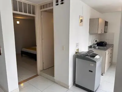 a small kitchen with a sink and a refrigerator at Amoblados Medellin Estadio in Medellín