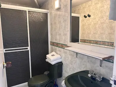 a bathroom with a sink and a shower with a mirror at Amoblados Medellin Estadio in Medellín