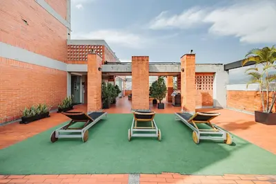 a group of lounge chairs on a patio at Orange Suites by Vibra Bonita in Medellín