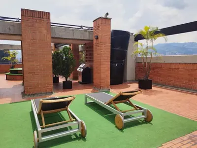 two lounge chairs and a table on a patio at Orange Suites by Vibra Bonita in Medellín