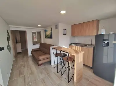a kitchen with a table and a couch in a room at Apartaestudio S101 a 2 calles de Milán Urbanevo in Manizales