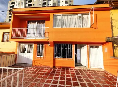 an orange house with white doors and a brick floor at Apartaestudio S101 a 2 calles de Milán Urbanevo in Manizales
