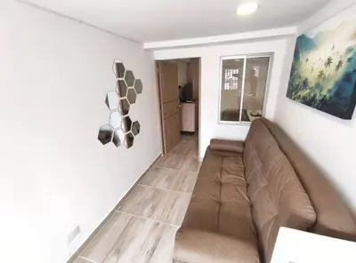 a living room with a brown couch in a room at Apartaestudio S101 a 2 calles de Milán Urbanevo in Manizales