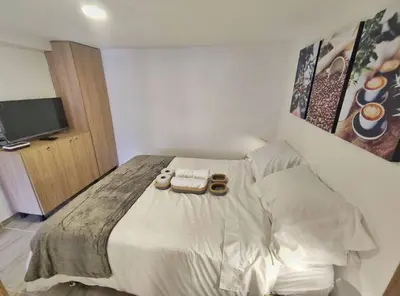 a bedroom with a bed with a tv on it at Apartaestudio S101 a 2 calles de Milán Urbanevo in Manizales