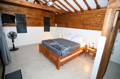 a bedroom with a bed in a room with wooden walls at Eco Hotel La Italia- Hotel Venecia, Antioquia in Venecia