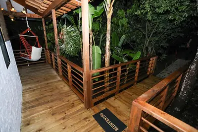 a wooden deck with a hammock and some plants at Eco Hotel La Italia- Hotel Venecia, Antioquia in Venecia