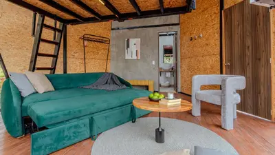 a living room with a green couch and a chair at Shabbat Hotel Boutique in San Vicente