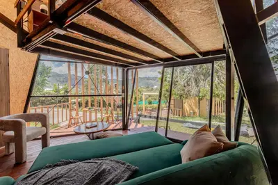 a living room with a green couch and large windows at Shabbat Hotel Boutique in San Vicente