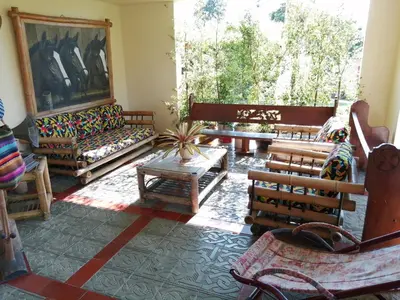 a living room with wooden furniture and a large window at Finca villa carolina, eje cafetero in La Floresta