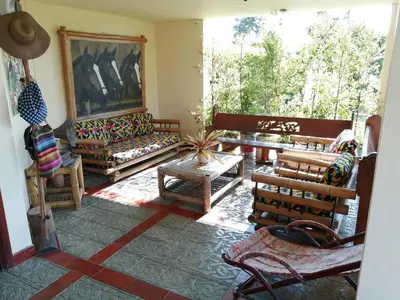 a living room filled with furniture and a large window at Finca villa carolina, eje cafetero in La Floresta