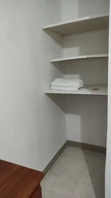 a closet with white shelves with towels on it at Habitación con baño privado#5 in Medellín