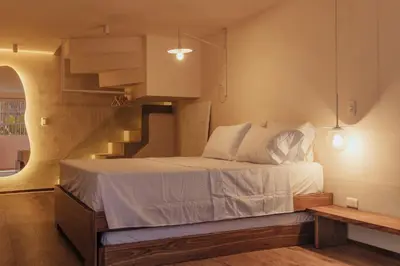 a bedroom with a bed with a staircase in the background at NEW Cozy Duplex in Laureles with A/C and WI-FI in Medellín