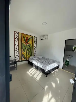 a room with a bed with a painting on the wall at finca campestre las heliconias in Puerto Triunfo