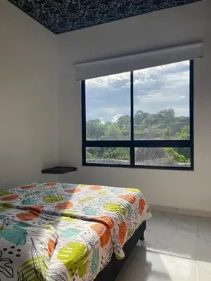 a bedroom with a bed and a large window at finca campestre las heliconias in Puerto Triunfo