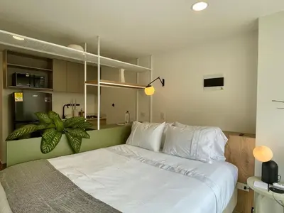 a bedroom with a large white bed with a plant at Oliving by Wynwood House in Medellín