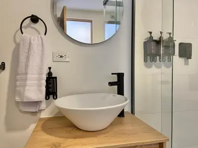 a bathroom with a white bowl sink and a mirror at Oliving by Wynwood House in Medellín