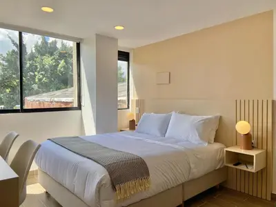a bedroom with a bed and a large window at Oliving by Wynwood House in Medellín