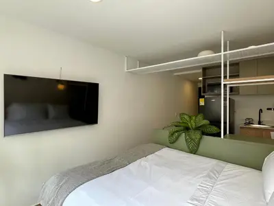 a bedroom with a bed and a tv on the wall at Oliving by Wynwood House in Medellín