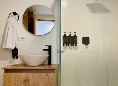 a bathroom with a sink and a mirror and a shower at Oliving by Wynwood House in Medellín
