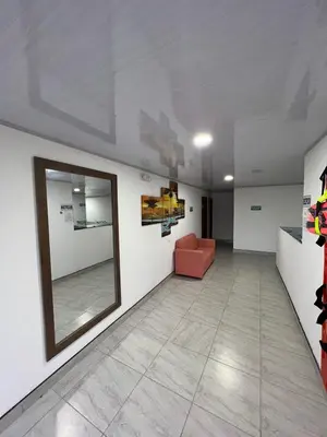 a waiting room with a red couch and a mirror at HOTEL NORCASIA RIOS Y AVENTURAS in Norcasia