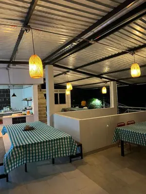 a room with two tables and a kitchen with lights at HOTEL NORCASIA RIOS Y AVENTURAS in Norcasia