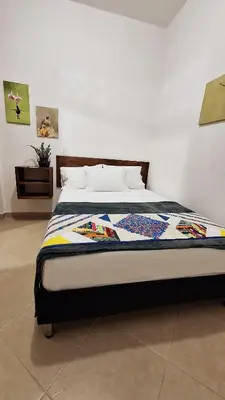 a bedroom with a bed with a quilt on it at Volarte Hotel in Jardin