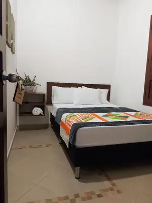 a bedroom with a bed and a plant on a table at Volarte Hotel in Jardin