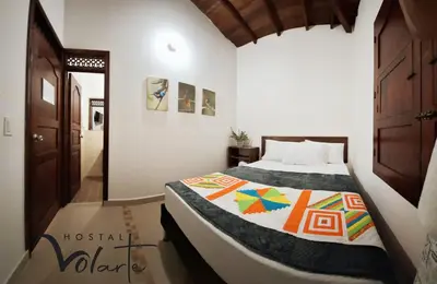 a bedroom with a bed with a colorful quilt on it at Volarte Hotel in Jardin