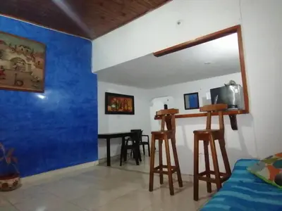 a room with a bed and a table and stools at Casa low cost in La Dorada