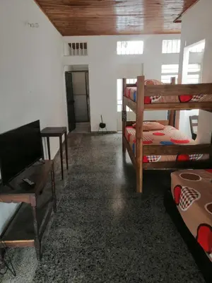 a room with bunk beds and a desk and a television at Casa low cost in La Dorada