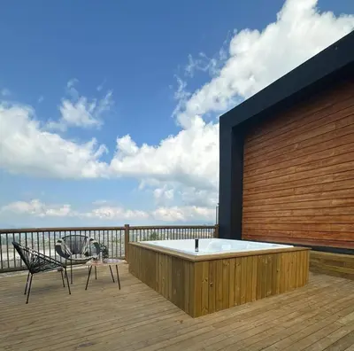 a hot tub on a deck with a table and chairs at Montecielo Hosting in Guatapé