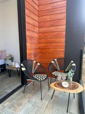two chairs and a table in front of a wall at Montecielo Hosting in Guatapé