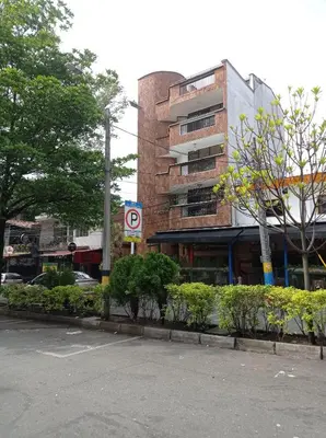 a building on a city street with a parking lot at cool de laureles Medellín in Medellín